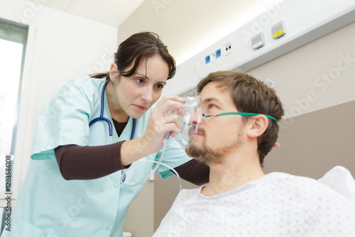 female doctor holding oxygen mask over male patients mouth