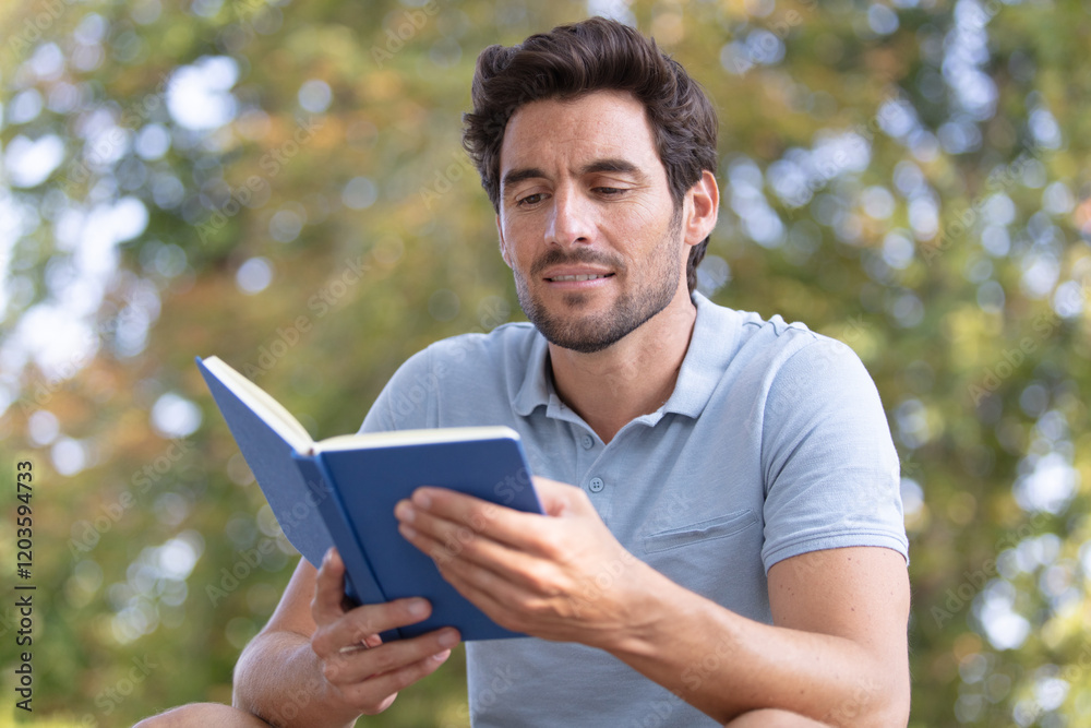 man reading a book in the park