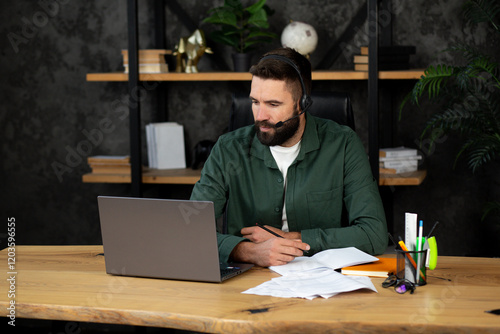 Call center agent talking, wearing a headset and helping people online with a desktop computer in office at work. Young male customer service worker, operator and helpline employee giving support