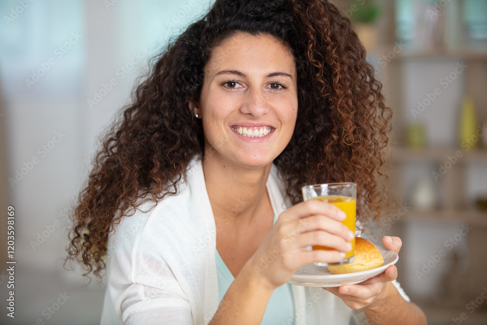 young lady holding orange juice and a pastry young lady holding orange juice and a pastry