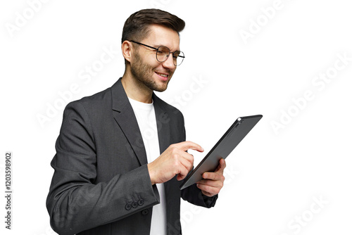 Young man in business attire smiling while using a tablet in a professional setting