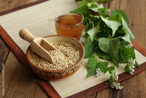 Herbal tea made from buckwheat seed, lat. Fagopyrum esculentum, fresh flowering plant next to it. The whole plant is full of rutin good against varicose veins. photo