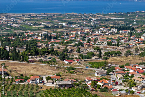 Obraz na płótnie Aerial view of Ancient Corinth, Greece, showcasing the Temple of Apollo, historical ruins, traditional architecture, and the scenic Gulf of Corinth in the background. w salonie