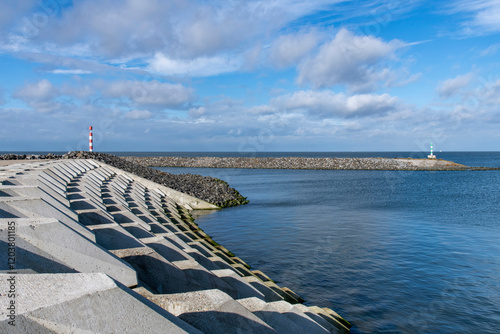 Port of escape on former Breezand working island on Afsluitdijk (dam separates IJsselmeer lake from Wadden Sea), the Netherlands  against a white clouded blue sky