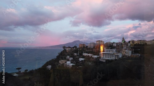Landscape of the Sorrento coast at sunset with the reflection of a flame during a windy and cloudy day.