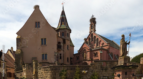 Chappel of saint Leon IX in Eguisheim, France. Wide-angle landscape view of ancient buildings against blue sky. Traditional architecture in Alsace in northeastern France. Travel and tourism concept