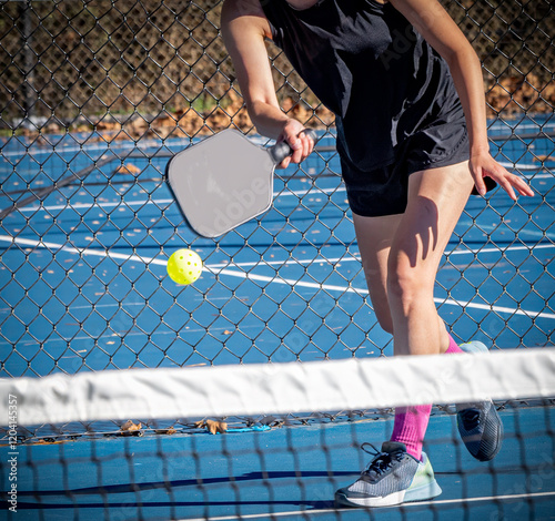 Female pickelball player about to hit a forehand volley