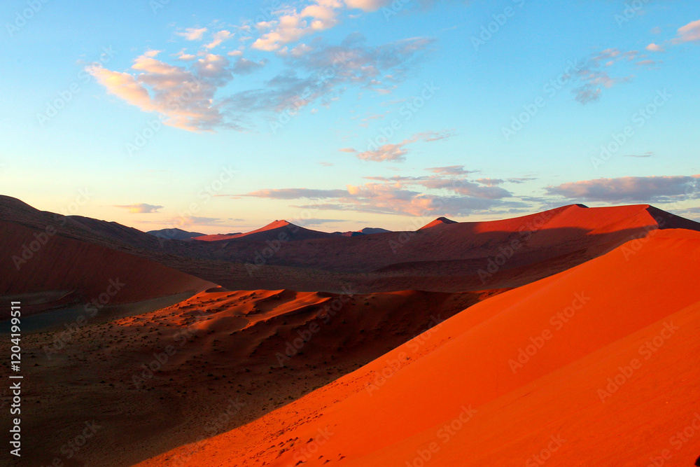 Fototapeta premium Red sand dunes at sunrise in Sossusvlei in the Namib Desert, Namibia 