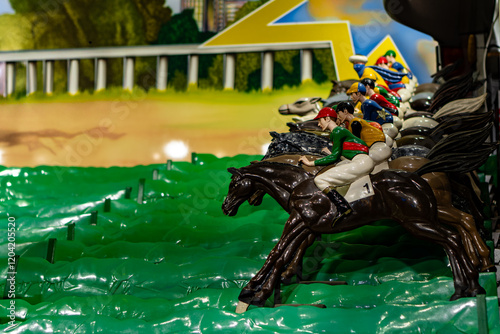 A group of toy horses are racing on a track