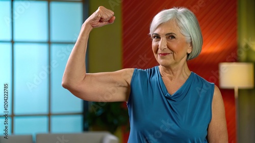 Confident Woman Flexing Arm with Silver Hair in Stylish Top, Woman flexing her arm with pride concept.