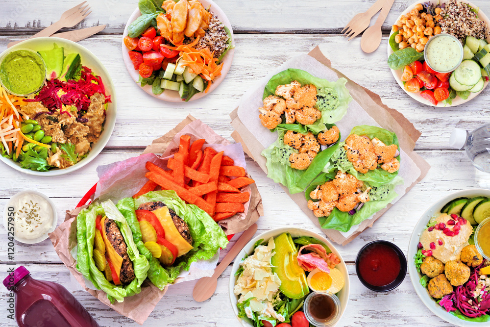 Healthy take out fast food table scene. Above view over a white wood background. Lettuce bean burgers with sweet potato fries, nutritious bowls, lettuce wraps and smoothie drink. Healthy take out fast food table scene. Above view over a white wood background. Lettuce bean burgers with sweet potato fries, nutritious bowls, lettuce wraps and smoothie drink.