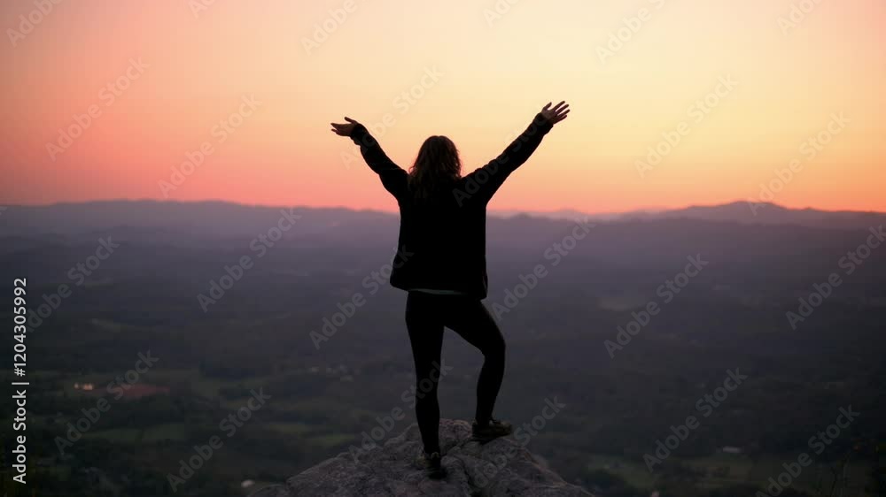 Vertical screen Silhouette of Woman Celebrating Sunrise Buffalo Mountain woman stands triumphantly on rock arms raised overlooking vast landscapes Buffalo Mountain Park during serene sunrise adventure Vertical screen Silhouette of Woman Celebrating Sunrise Buffalo Mountain woman stands triumphantly on rock arms raised overlooking vast landscapes Buffalo Mountain Park during serene sunrise adventure