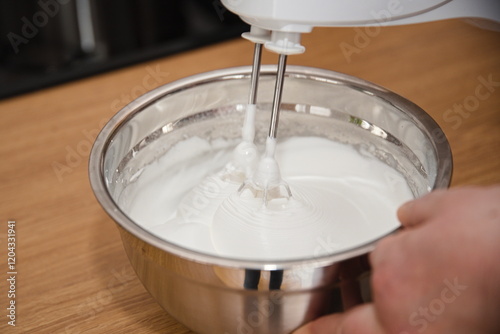 Person bereitet Eischnee mit elektrischem Mixer zu - Baiser photo
