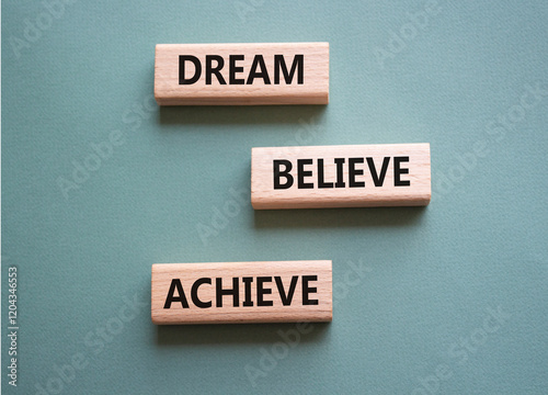 Dream Believe Achieve symbol. Wooden blocks with words Dream Believe Achieve. Beautiful grey green background. Business and Dream Believe Achieve concept. Copy space.