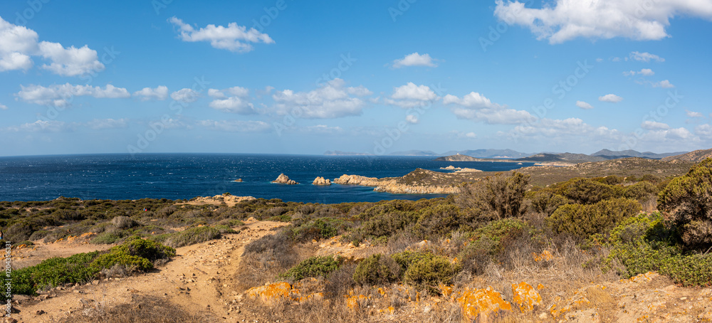 Landscape of the south-west coast of Sardinia with cliffs, blue sea, fjords and white clouds