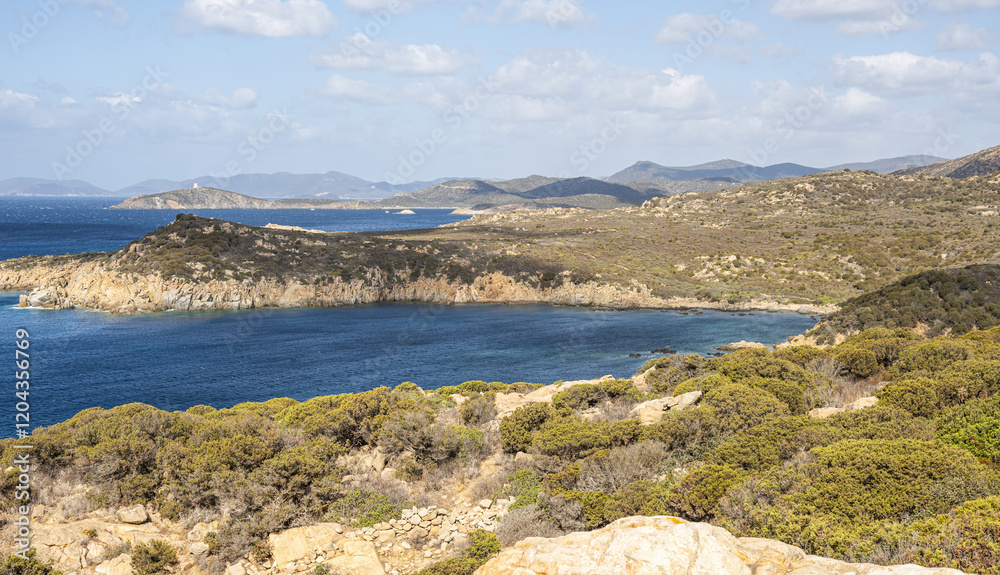 Landscape of the south-west coast of Sardinia with cliffs, blue sea, fjords and white clouds