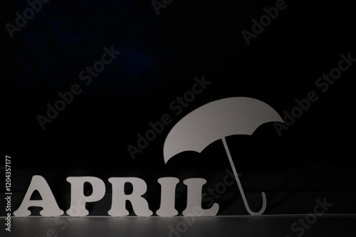 April spelled out against a black background with an umbrella photo