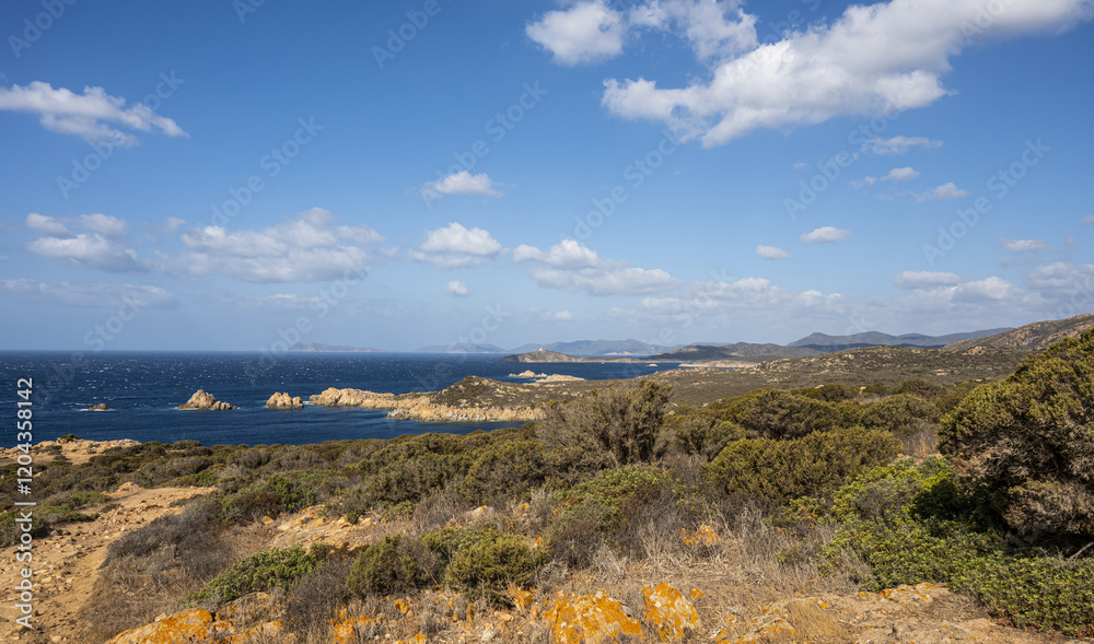 Landscape of the south-west coast of Sardinia with cliffs, blue sea, fjords and white clouds