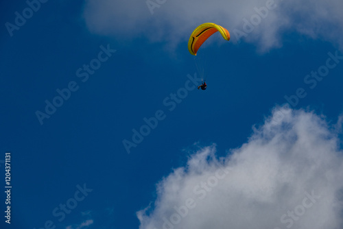 Fototapeta Naklejka Na Ścianę i Meble -  Paraglider flight against a blue sky with clouds. Beskidy Mountains, Poland