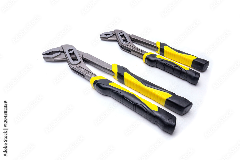 Two slip joint pliers with yellow and black handles lying on white background Two slip joint pliers with yellow and black handles lying on white background