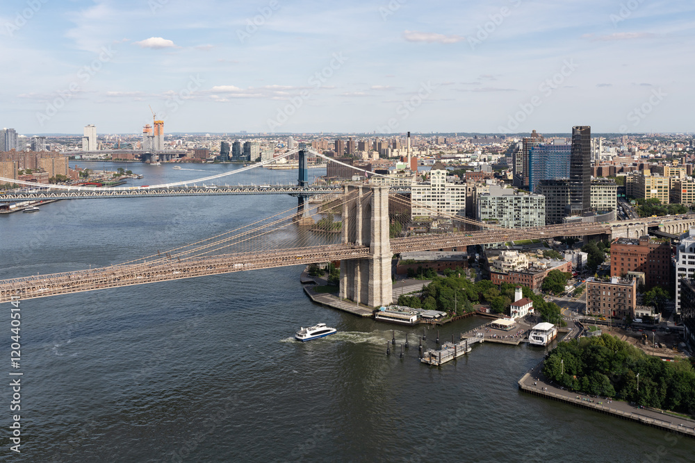 Aerial view of Brooklyn Bridge and Manhattan skyline on a sunny summer day.