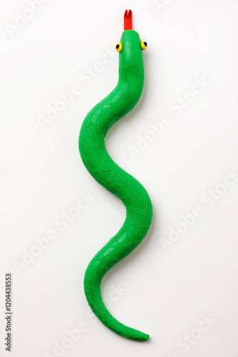 green plasticine snake on white background. top view