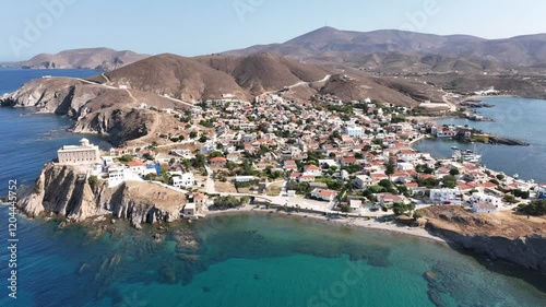 Aerial drone cinematic video of picturesque and historic main village of Psara island featuring landmark church of Saint Nikolas, North Aegean islands, Greece photo