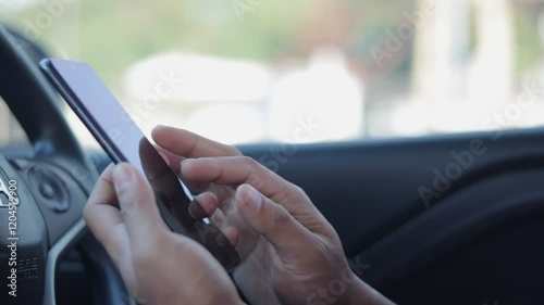 Young man hand using app on smartphone in car for lock or unlock. The concept for using technology, shopping online, message, search, email business. Internet social network browsing, phone addiction.