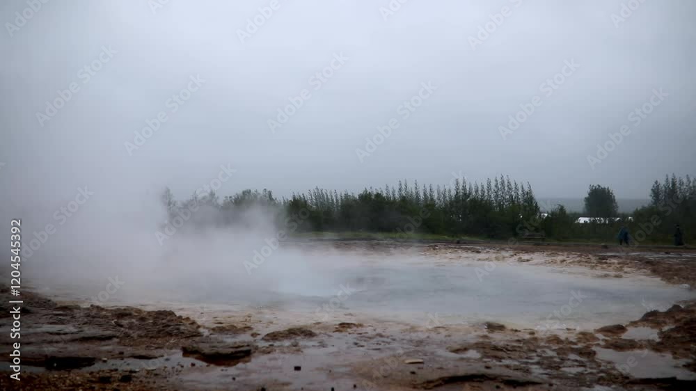 Famous Strokkur geyser erupting on a foggy rainy day in Iceland. Famous Strokkur geyser erupting on a foggy rainy day in Iceland.