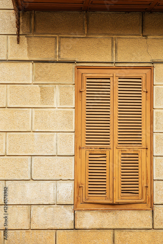 Weathered wooden shutters on rustic stone wall in urban setting