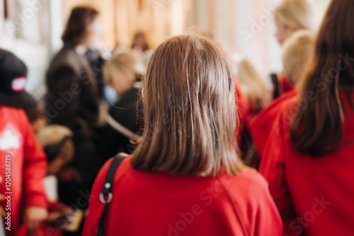 Group of kids children on excursion in a museum gallery, school pupils and students tour with guide, a docent with a tourists, young visitors wearing red, school field trip, art exhibition attendees