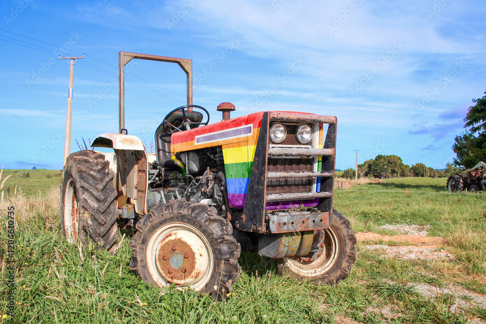 Agricultural tractor painted in the rainbow pride flag colours, outside on the farm in a rural area. Agricultural tractor painted in the rainbow pride flag colours, outside on the farm in a rural area.