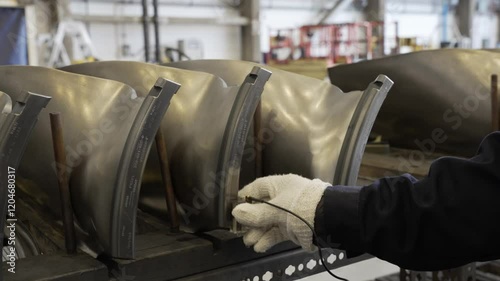 Ultrasonic inspection being performed on dovetail portion of airplane turbine engine fan blades.