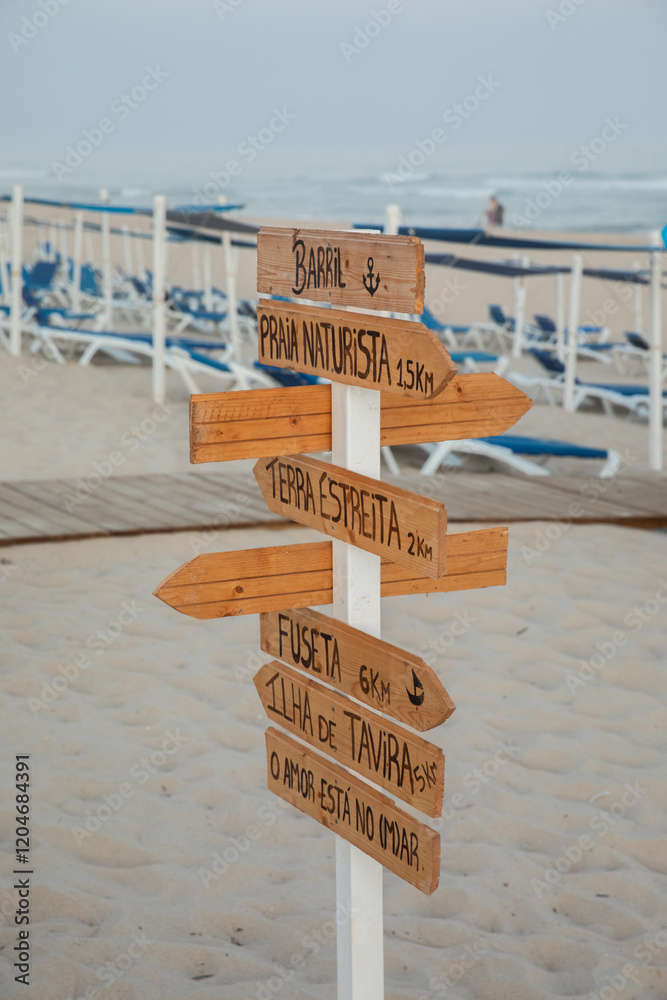 Wooden signpost on beach with multiple destinations