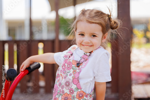 Preschool child riding bike in kindergarten yard