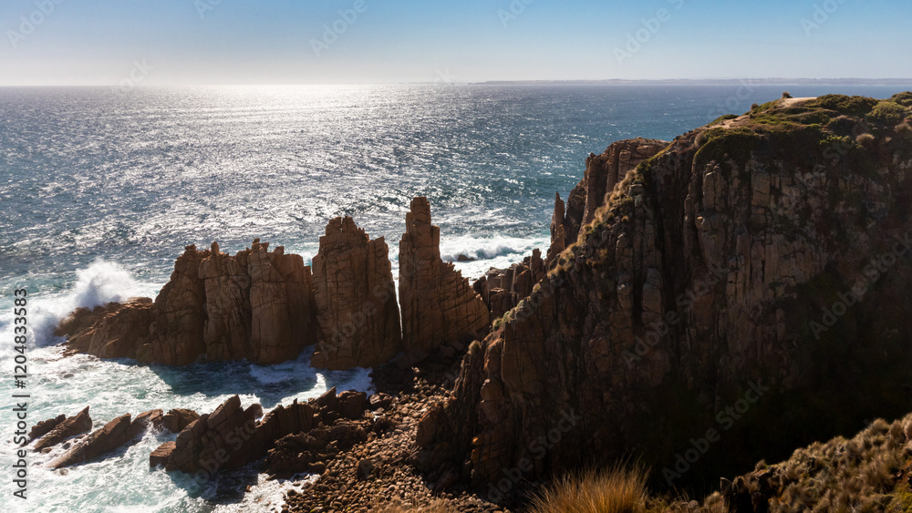 Fototapeta premium Coastal cliffs overlooking beach and ocean on a clear blue day