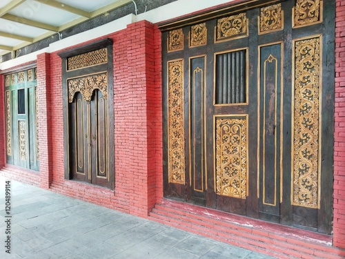 Wall with doors and windows in old wooden style and red-painted brick wall