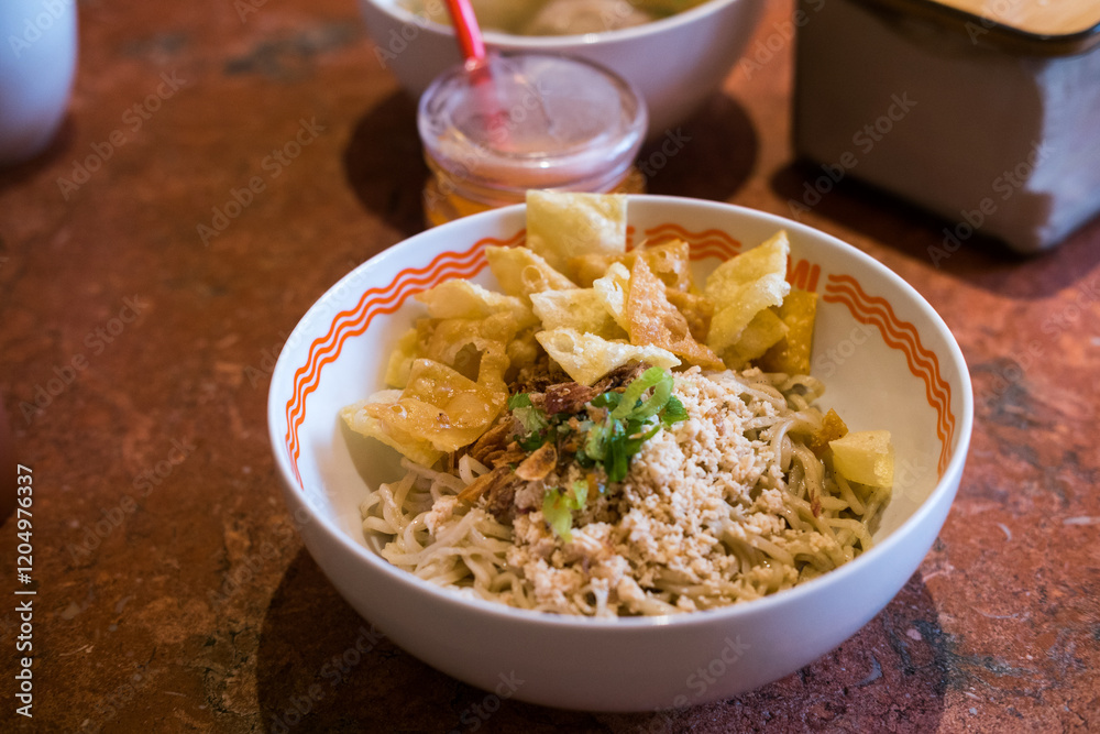 Indonesian sweet-savory noodles topped with seasoned minced chicken, crispy wontons crackers, and green onions. Served dry with separate broth. this is Mie Yamin asin Indonesian sweet-savory noodles topped with seasoned minced chicken, crispy wontons crackers, and green onions. Served dry with separate broth. this is Mie Yamin asin