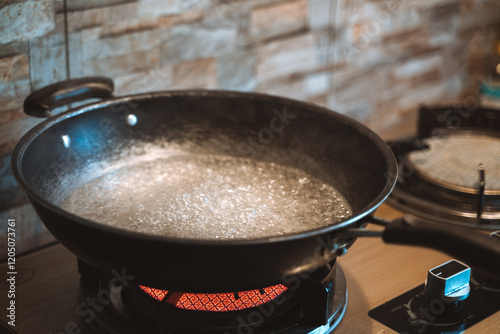 A boiling pot of water on a stovetop, emitting steam in a modern kitchen setting. photo