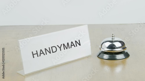 Handyman Office or Room with Hand Ringing The Bell on Desk or Table Multiple Times