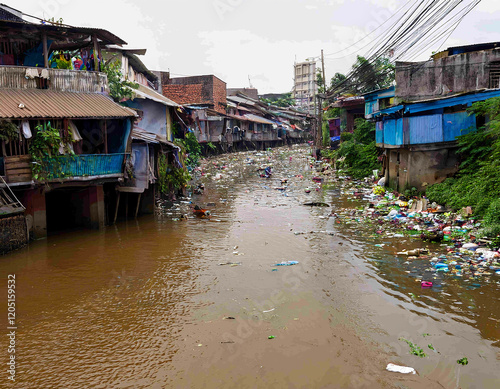 A river in a densely populated settlement with pollution and garbage in the dirty water. photo