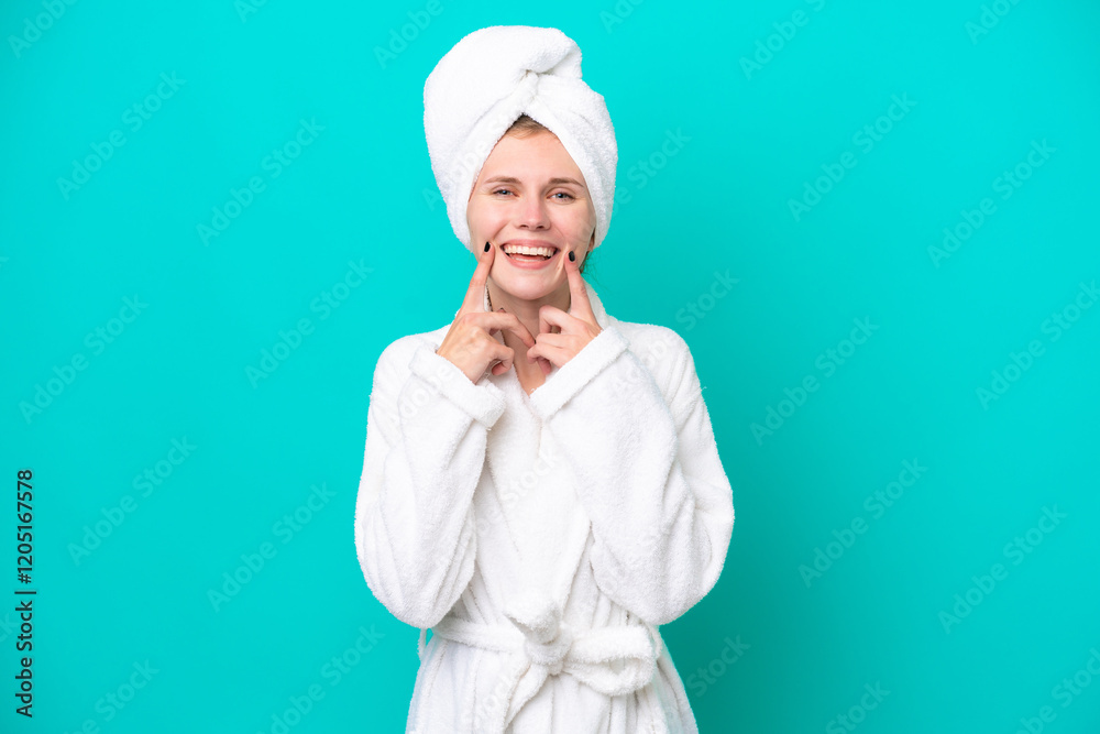 Young woman in a bathrobe isolated on blue background smiling with a happy and pleasant expression Young woman in a bathrobe isolated on blue background smiling with a happy and pleasant expression