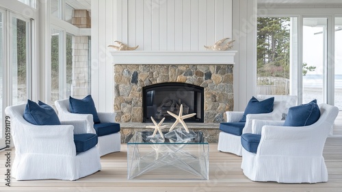 A serene beachside living room featuring a custom-built stone fireplace surrounded by white paneled walls. The space has plush armchairs with deep blue cushions