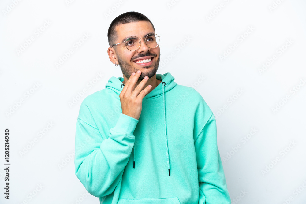 Young caucasian man isolated on white background looking up while smiling Young caucasian man isolated on white background looking up while smiling