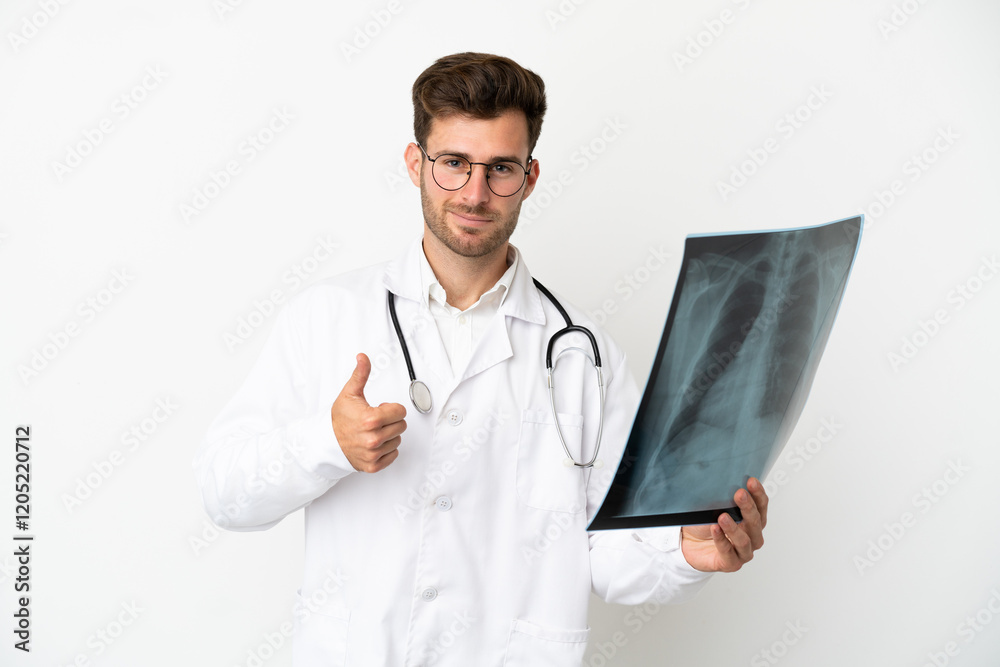 Young doctor caucasian man over isolated on white background wearing a doctor gown and holding a bone scan Young doctor caucasian man over isolated on white background wearing a doctor gown and holding a bone scan