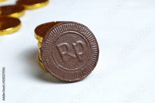 Indonesian chocolate coin candy or chocolate coin candy with garuda bird symbol and rupiah currency isolated on white photo