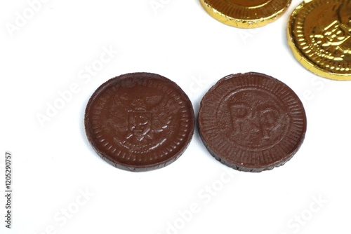 Indonesian chocolate coin candy or chocolate coin candy with garuda bird symbol and rupiah currency isolated on white photo