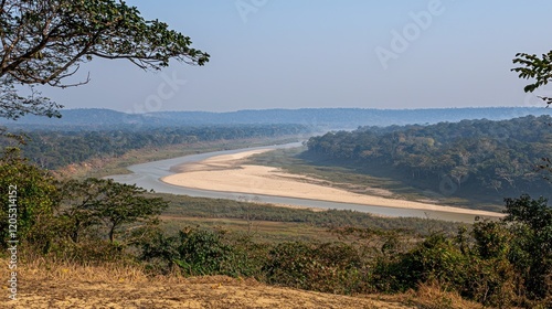 River bends through jungle vista, hazy hills
