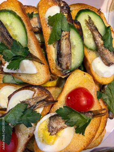 Fototapeta Naklejka Na Ścianę i Meble -  sandwich with sprats on toasted bread with egg, cucumber, tomato