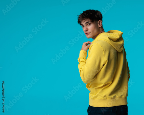 sexy casual man in yellow hoodie turning to camera